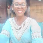 Femme africaine souriante d'environ 48 ans, regard confiant et apaisé, symbolisant une relation amoureuse retrouvée après consultation avec le voyant médium Nawan
